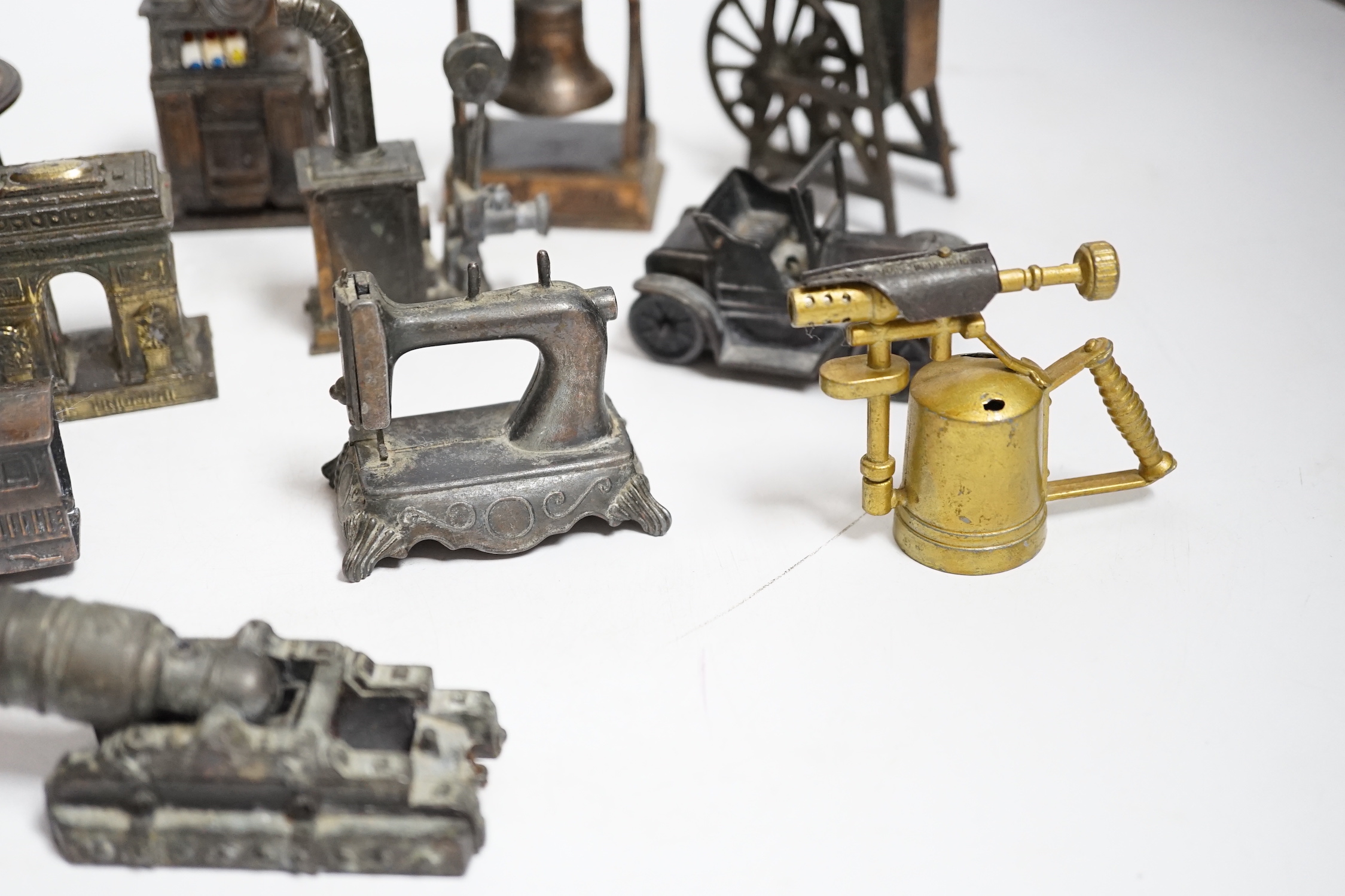 A collection of novelty metal pencil sharpeners and a pair of late Georgian silver plated candlesticks, 20cm